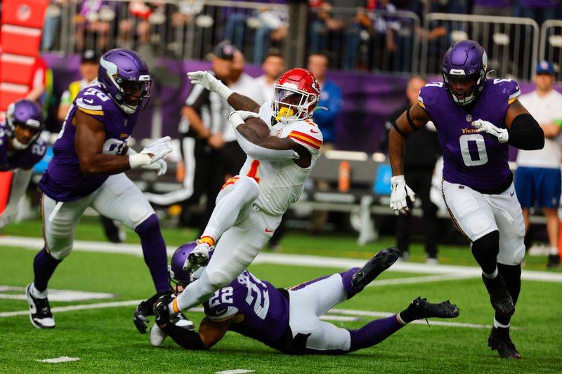 Kansas City Chiefs running back Jerick McKinnon (1) runs between Minnesota Vikings linebacker D.J. Wonnum (98), safety Harrison Smith (22) and linebacker Marcus Davenport (0) during the first half of an NFL football game, Sunday, Oct. 8, 2023, in Minneapolis. (AP Photo/Bruce Kluckhohn)