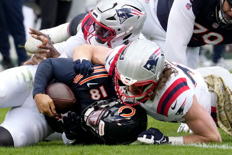 New England Patriots safety Brenden Schooler, right, sacks Chicago Bears quarterback Caleb Williams as linebacker Anfernee Jennings assists during the second half of an NFL football game Sunday, Nov. 10, 2024, in Chicago. (AP Photo/Nam Y. Huh)