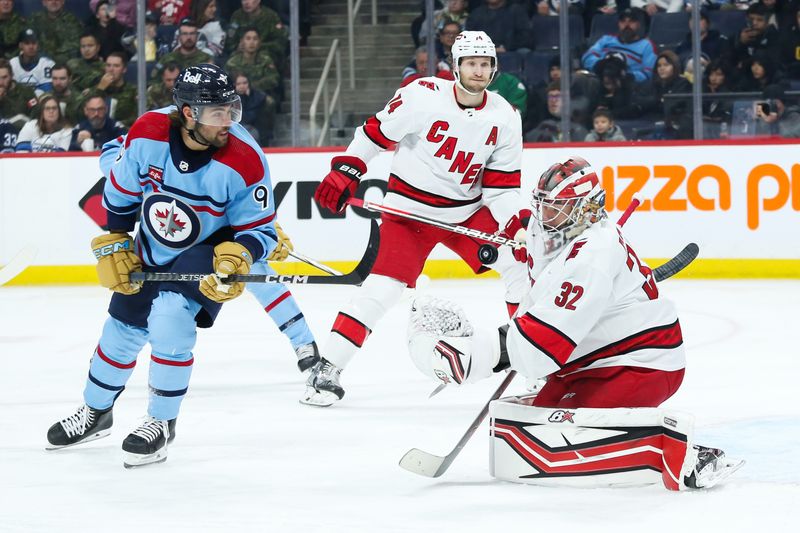 Dec 4, 2023; Winnipeg, Manitoba, CAN; Carolina Hurricanes goalie Antti Raanta (32) makes a save as Winnipeg Jets forward Alex Iafallo (9) looks for a rebound during the second period at Canada Life Centre. Mandatory Credit: Terrence Lee-USA TODAY Sports