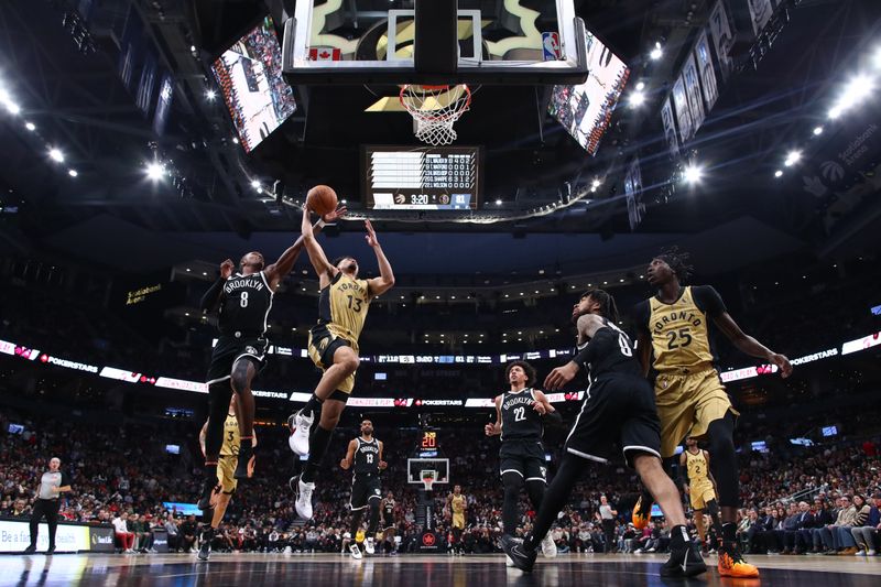 TORONTO, CANADA - FEBRUARY 22: Jordan Nwora #13 of the Toronto Raptors drives to the net against Lonnie Walker IV #8 of the Brooklyn Nets in the second half of their NBA game at Scotiabank Arena on February 22, 2024 in Toronto, Canada. NOTE TO USER: User expressly acknowledges and agrees that, by downloading and or using this photograph, User is consenting to the terms and conditions of the Getty Images License Agreement. (Photo by Cole Burston/Getty Images)