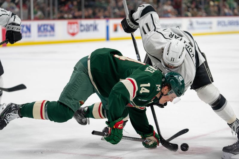 Feb 21, 2023; Saint Paul, Minnesota, USA; Minnesota Wild center Joel Eriksson Ek (14) is upended by Los Angeles Kings center Anze Kopitar (11) on the faceoff in the third period at Xcel Energy Center. Mandatory Credit: Matt Blewett-USA TODAY Sports