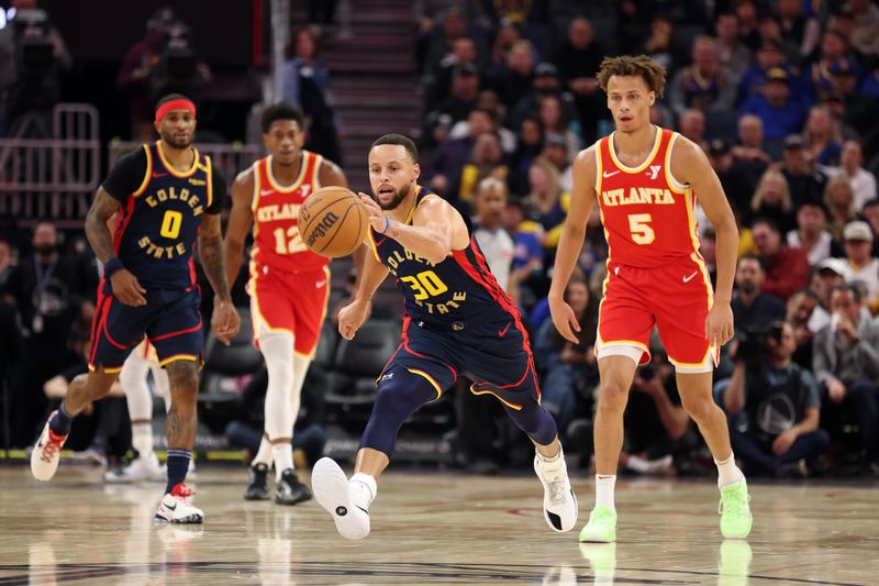 SAN FRANCISCO, CALIFORNIA - NOVEMBER 20: Stephen Curry #30 of the Golden State Warriors reaches for a loose ball while guarded by Dyson Daniels #5 of the Atlanta Hawks in the first half at Chase Center on November 20, 2024 in San Francisco, California. NOTE TO USER: User expressly acknowledges and agrees that, by downloading and/or using this photograph, user is consenting to the terms and conditions of the Getty Images License Agreement.   (Photo by Ezra Shaw/Getty Images)