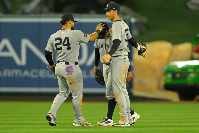 May 26, 2025; Anaheim, California, USA;  New York Yankees left fielder Jasson Dominguez (24), center fielder Trent Grisham (12) and right fielder Cody Bellinger (35) hug after the final out of the ninth inning against the Los Angeles Angels at Angel Stadium. Mandatory Credit: Jayne Kamin-Oncea-Imagn Images