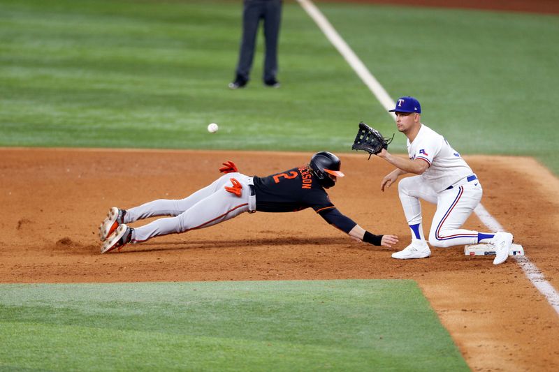 Oct 10, 2023; Arlington, Texas, USA; Baltimore Orioles third baseman Gunnar Henderson (2) slides against Texas Rangers first baseman Nathaniel Lowe (30) in the fifth inning during game three of the ALDS for the 2023 MLB playoffs at Globe Life Field. Mandatory Credit: Andrew Dieb-USA TODAY Sports