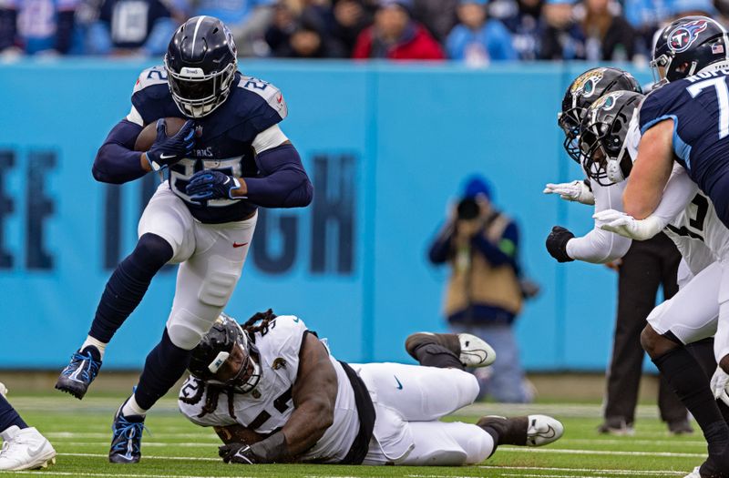 Tennessee Titans running back Derrick Henry (22) escapes from Jacksonville Jaguars defensive tackle DaVon Hamilton (52) as he runs for yardage during their NFL football game Sunday, Jan. 7, 2024, in Nashville, Tenn. (AP Photo/Wade Payne)