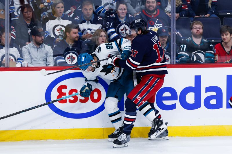 Oct 18, 2024; Winnipeg, Manitoba, CAN;  Winnipeg Jets forward Adam Lowry (17) checks San Jose Sharks defenseman Jake Walman (96) during the third period at Canada Life Centre. Mandatory Credit: Terrence Lee-Imagn Images