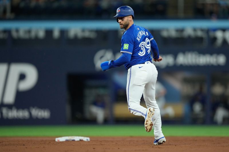 Apr 14, 2024; Toronto, Ontario, CAN; Toronto Blue Jays center fielder Kevin Kiermaier (39) heads to second base on a throwing error by Colorado Rockies starting pitcher Kyle Freeland (not pictured) during the third inning at Rogers Centre. Mandatory Credit: John E. Sokolowski-USA TODAY Sports