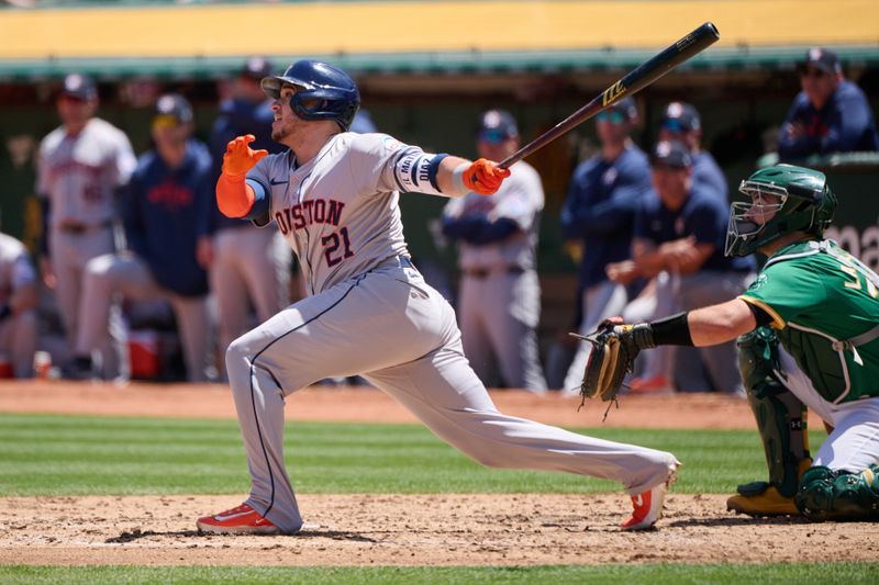 May 26, 2024; Oakland, California, USA; Houston Astros catcher Yainer Diaz (21) hits an RBI sacrifice fly ball against the Oakland Athletics during the fourth inning at Oakland-Alameda County Coliseum. Mandatory Credit: Robert Edwards-USA TODAY Sports