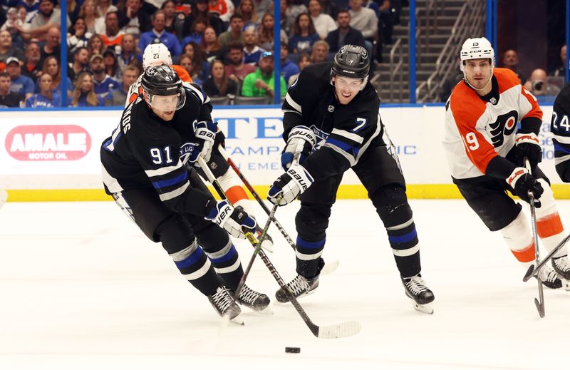 Mar 9, 2024; Tampa, Florida, USA; Tampa Bay Lightning center Steven Stamkos (91) and Tampa Bay Lightning defenseman Haydn Fleury (7) defend the puck against the Philadelphia Flyers during the second period at Amalie Arena. Mandatory Credit: Kim Klement Neitzel-USA TODAY Sports