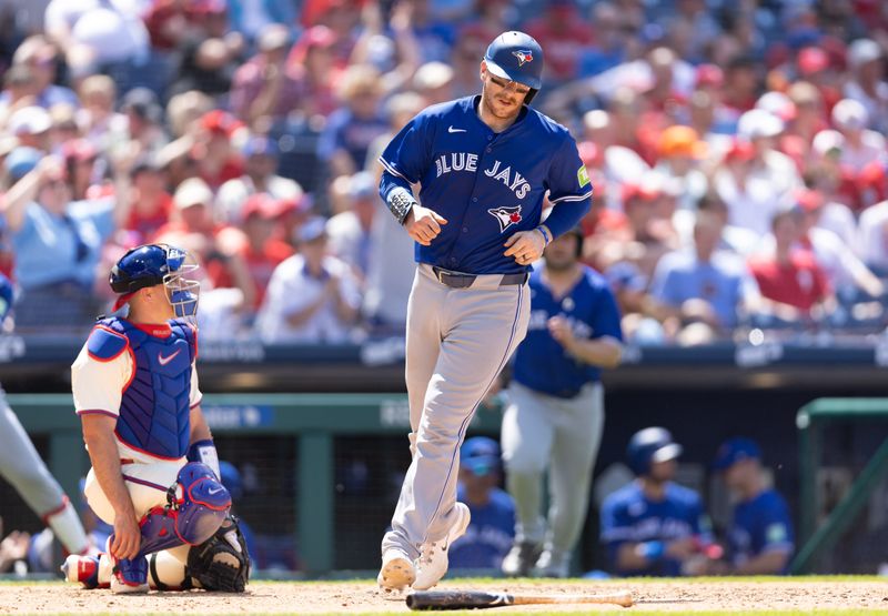 May 8, 2024; Philadelphia, Pennsylvania, USA; Toronto Blue Jays catcher Danny Jansen (9) scores a run in front of Philadelphia Phillies catcher J.T. Realmuto (10) during the sixth inning at Citizens Bank Park. Mandatory Credit: Bill Streicher-USA TODAY Sports