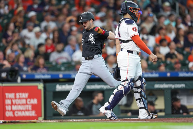 Aug 17, 2024; Houston, Texas, USA; Chicago White Sox left fielder Andrew Benintendi (23) scores a run past Houston Astros catcher Yainer Diaz (21) during the first inning at Minute Maid Park. Mandatory Credit: Troy Taormina-USA TODAY Sports