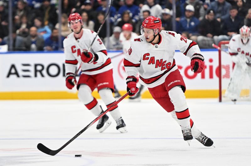 Dec 30, 2023; Toronto, Ontario, CAN; Carolina Hurricanes forward Sebastian Aho (20) skates with the puck against the Toronto Maple Leafs in the second period at Scotiabank Arena. Mandatory Credit: Dan Hamilton-USA TODAY Sports