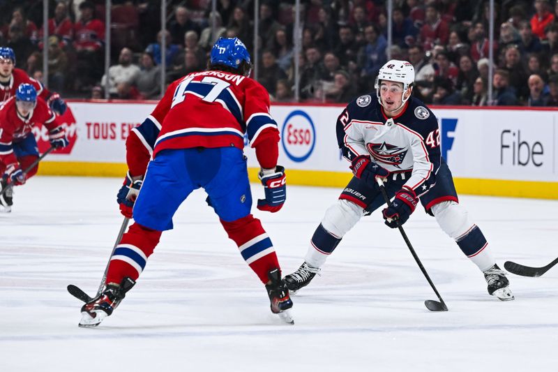 Mar 12, 2024; Montreal, Quebec, CAN; Columbus Blue Jackets center Alexandre Texier (42) plays the puck against Montreal Canadiens right wing Josh Anderson (17) during the second period at Bell Centre. Mandatory Credit: David Kirouac-USA TODAY Sports