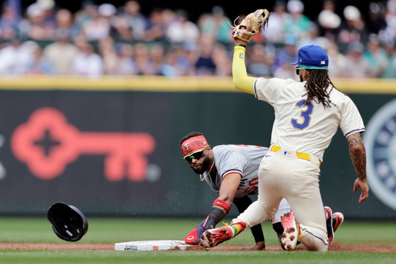 Jun 30, 2024; Seattle, Washington, USA; Minnesota Twins shortstop Willi Castro (50) steals second with Seattle Mariners shortstop J.P. Crawford (3) holding his glove up after a late tag during the first inning at T-Mobile Park. Mandatory Credit: John Froschauer-USA TODAY Sports