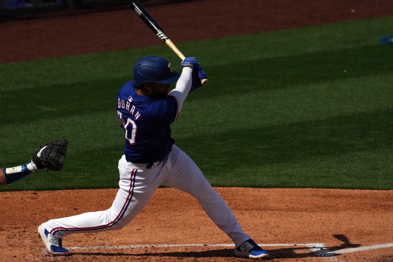 Feb 28, 2024; Surprise, Arizona, USA; Texas Rangers shortstop Ezequiel Duran (20) bats against the Los Angeles Dodgers during the third inning at Surprise Stadium. Mandatory Credit: Joe Camporeale-USA TODAY Sports