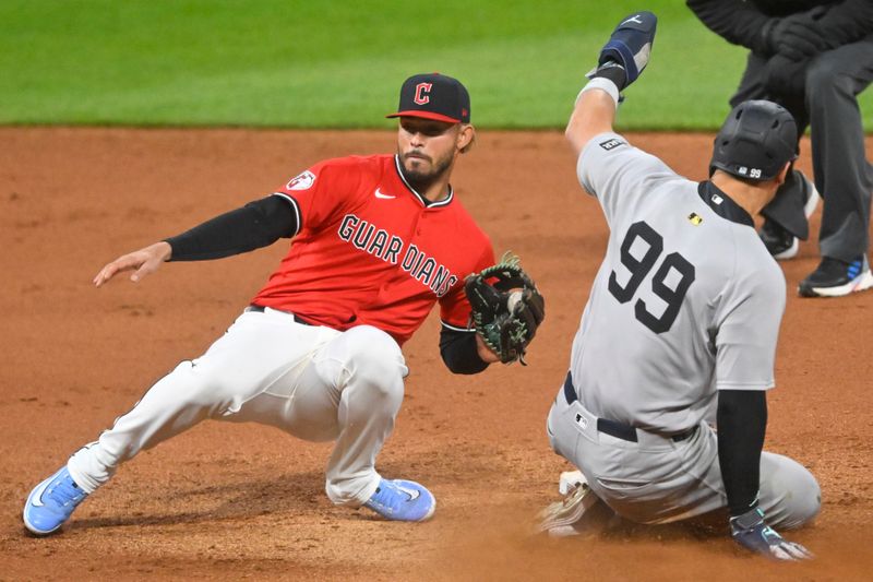 Apr 22, 2025; Cleveland, Ohio, USA; New York Yankees right fielder Aaron Judge (99) steals second base beside Cleveland Guardians second baseman Gabriel Arias (13) in the eighth inning at Progressive Field. Mandatory Credit: David Richard-Imagn Images