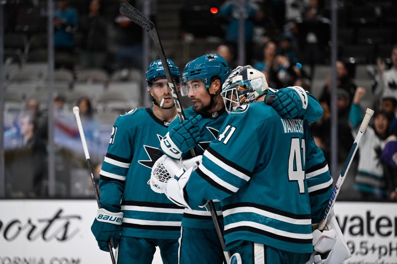 Oct 29, 2024; San Jose, California, USA; San Jose Sharks defenseman Cody Ceci (center) celebrates with center Alexander Wennberg (left) and goaltender Vitek Vanecek (right) after their win over the Los Angeles Kings at SAP Center at San Jose. Mandatory Credit: Eakin Howard-Imagn Images