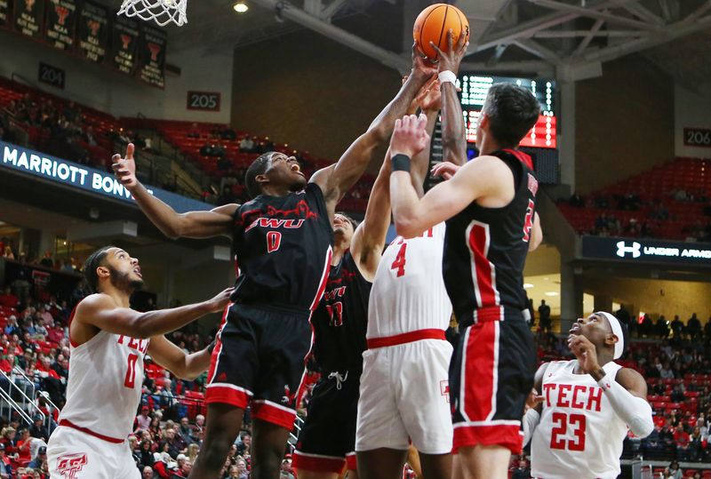 Dec 13, 2022; Lubbock, Texas, USA; Eastern Washington Eagles forward Cedric Coward (0) grabs a rebound in front of Texas Tech Red Raiders forward Robert Jennings (4) in the first half at United Supermarkets Arena. Mandatory Credit: Michael C. Johnson-USA TODAY Sports