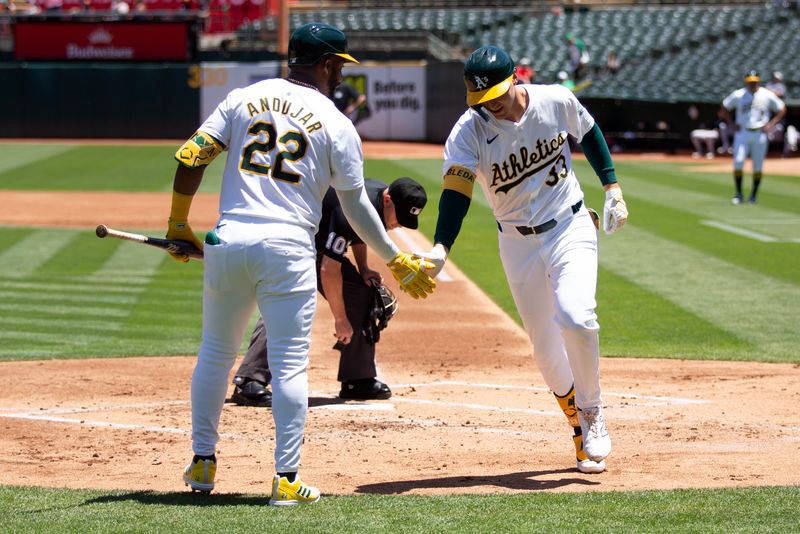 Jun 22, 2024; Oakland, California, USA; Oakland Athletics center fielder JJ Bleday (33) gets a congratulatory handshake from teammate Miguel Andujar (22) after hitting a solo home run against the Minnesota Twins during the first inning at Oakland-Alameda County Coliseum. Mandatory Credit: D. Ross Cameron-USA TODAY Sports