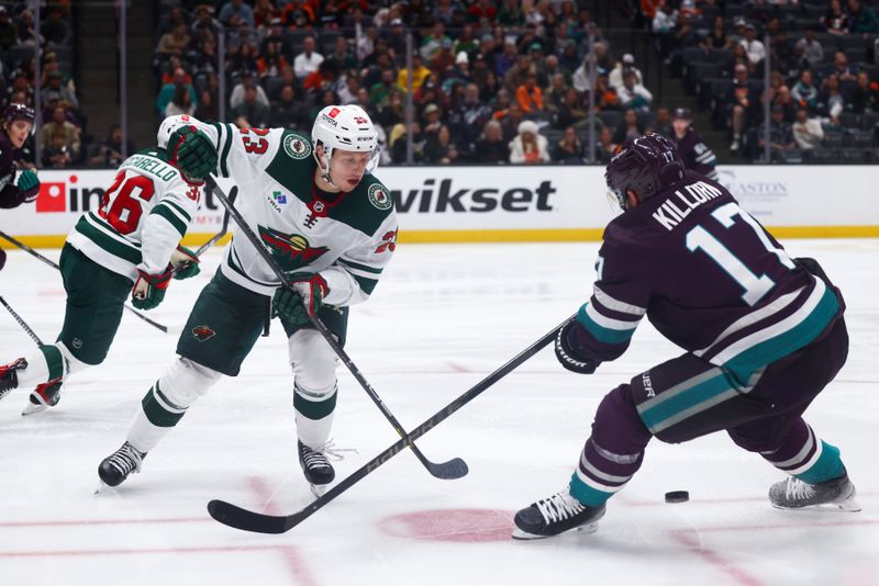 Mar 19, 2024; Anaheim, California, USA; Minnesota Wild center Marco Rossi (23) passes the puck through the legs of Anaheim Ducks left wing Alex Killorn (17) during the second period ofna game at Honda Center. Mandatory Credit: Jessica Alcheh-USA TODAY Sports