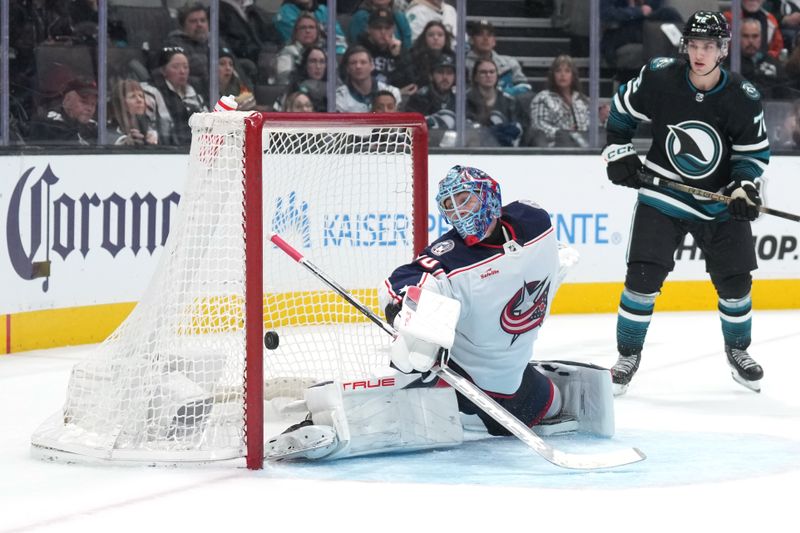 Feb 17, 2024; San Jose, California, USA; A shot by San Jose Sharks left wing Fabian Zetterlund (not shown) gets past Columbus Blue Jackets goaltender Elvis Merzlikins (center) for a goal during the second period at SAP Center at San Jose. Mandatory Credit: Darren Yamashita-USA TODAY Sports