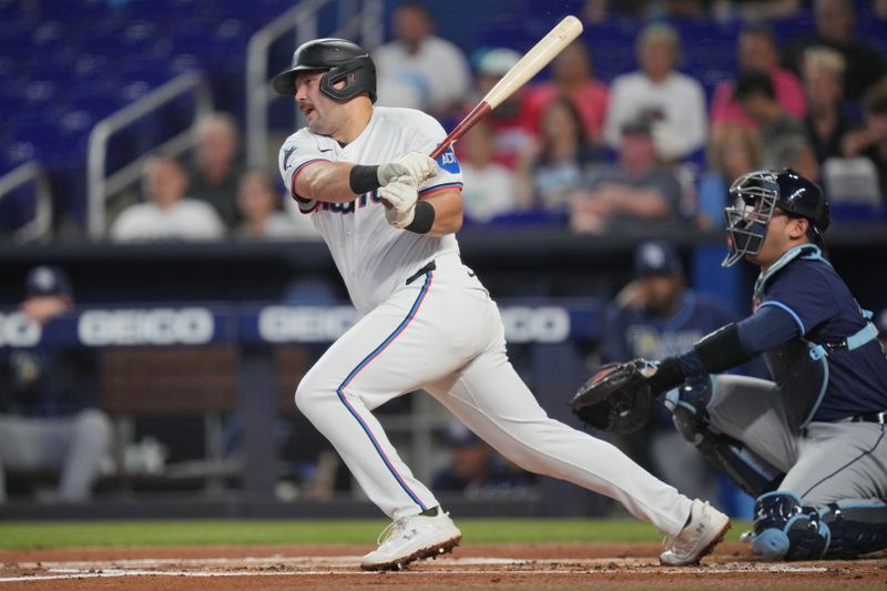 Jun 4, 2024; Miami, Florida, USA; Miami Marlins third baseman Jake Burger (36) hits an infield single against the Tampa Bay Rays in the first inning at loanDepot Park. Mandatory Credit: Jim Rassol-USA TODAY Sports