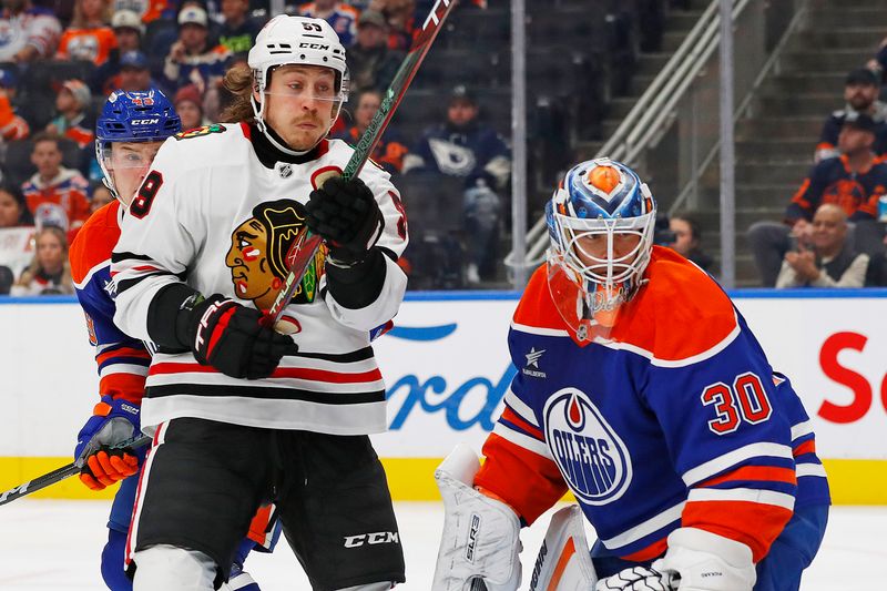 Oct 12, 2024; Edmonton, Alberta, CAN; Chicago Blackhawks forward Tyler Bertuzzi (59) and Edmonton Oilers goaltender Calvin Pickard (30) look for a loose puck during the second period at Rogers Place. Mandatory Credit: Perry Nelson-Imagn Images