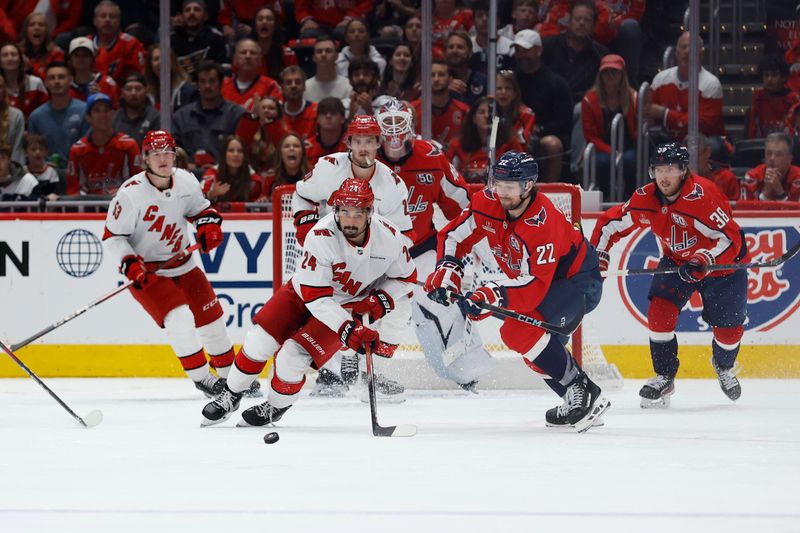 May 6, 2025; Washington, District of Columbia, USA; Carolina Hurricanes center Seth Jarvis (24) and Washington Capitals right wing Brandon Duhaime (22) battle for the puck in the third period in game one of the second round of the 2025 Stanley Cup Playoffs at Capital One Arena. Mandatory Credit: Geoff Burke-Imagn Images