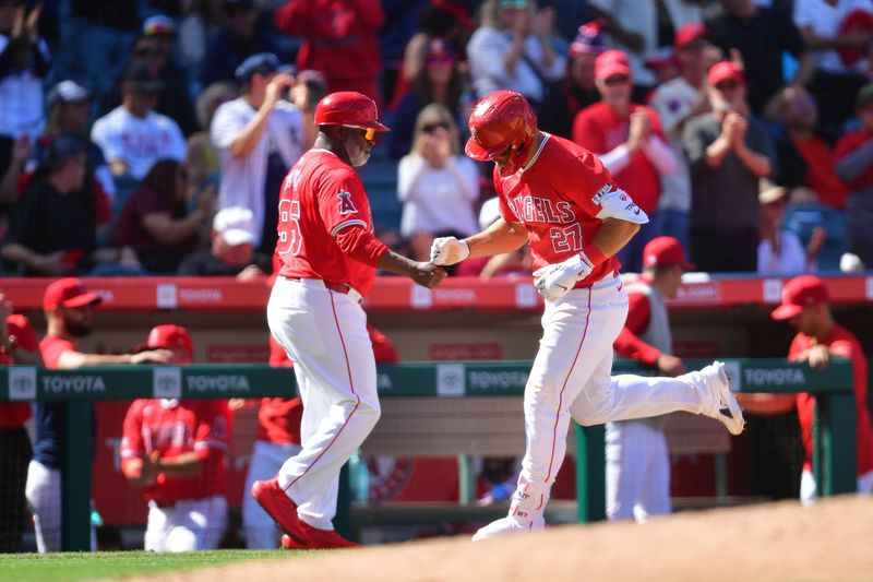 Apr 7, 2024; Anaheim, California, USA;  Los Angeles Angels center fielder Mike Trout (27) is greeted by third base coach Eric Young Sr. (85) after hitting a solo home run against the Boston Red Sox during the eighth inning at Angel Stadium. Mandatory Credit: Gary A. Vasquez-USA TODAY Sports