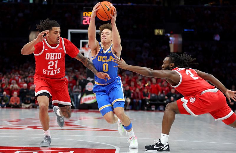 Jan 17, 2026; Columbus, Ohio, USA; UCLA Bruins guard Trent Perry (0) drives to the basket as Ohio State Buckeyes forward Devin Royal (21) and guard Bruce Thornton (2) defend during the first half at Value City Arena. Mandatory Credit: Joseph Maiorana-Imagn Images