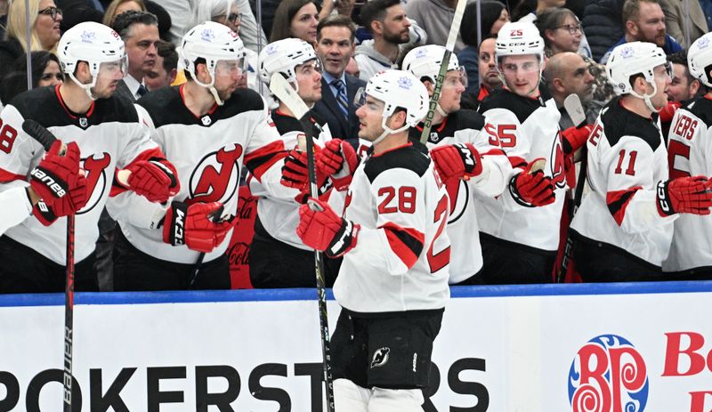 Apr 11, 2024; Toronto, Ontario, CAN; New Jersey Devils forward Timo Meier (28) celebrates with team mates at the bench after scoring a goal against the Toronto Maple Leafs in the first period at Scotiabank Arena. Mandatory Credit: Dan Hamilton-USA TODAY Sports