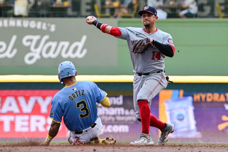 Jul 14, 2024; Milwaukee, Wisconsin, USA; Washington Nationals second baseman Ildemaro Vargas (14) attempts a double play after forcing out Milwaukee Brewers third baseman Joey Ortiz (3) in the second inning at American Family Field. Mandatory Credit: Benny Sieu-USA TODAY Sports