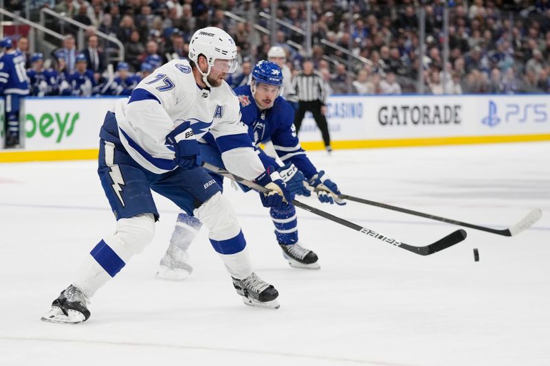 Nov 6, 2023; Toronto, Ontario, CAN; Tampa Bay Lightning defenseman Victor Hedman (77) clears the puck past Toronto Maple Leafs forward Auston Matthews (34) during the first period at Scotiabank Arena. Mandatory Credit: John E. Sokolowski-USA TODAY Sports