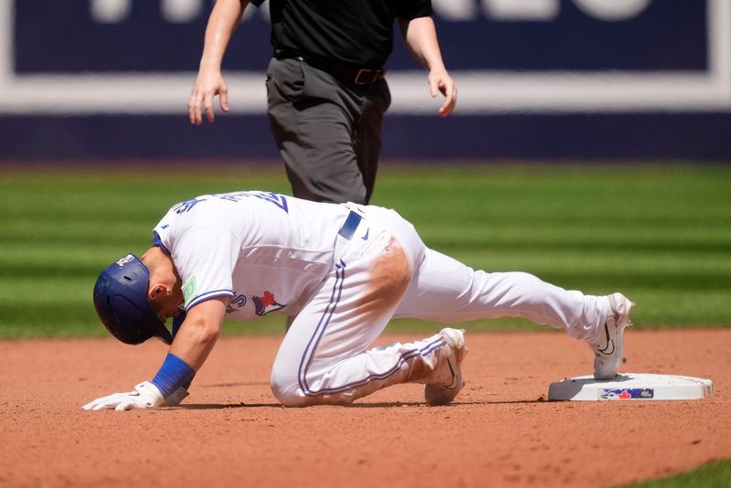 Jul 30, 2023; Toronto, Ontario, CAN; Toronto Blue Jays center fielder Daulton Varsho (25) keeps his foot on second base against the Los Angeles Angels during the seventh inning at Rogers Centre. Mandatory Credit: John E. Sokolowski-USA TODAY Sports