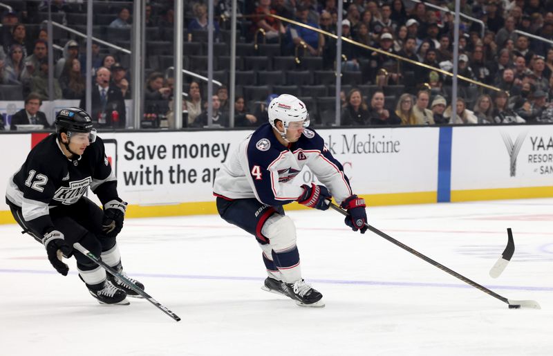 Nov 9, 2024; Los Angeles, California, USA; Columbus Blue Jackets center Cole Sillinger (4) takes the puck from Los Angeles Kings left wing Trevor Moore (12) during the third period at Crypto.com Arena. Mandatory Credit: Jason Parkhurst-Imagn Images