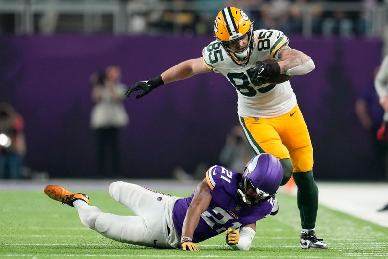 Green Bay Packers' Tucker Kraft ties to run past Minnesota Vikings' Akayleb Evans after a catch during the second half of an NFL football game Sunday, Dec. 31, 2023, in Minneapolis. (AP Photo/Abbie Parr)