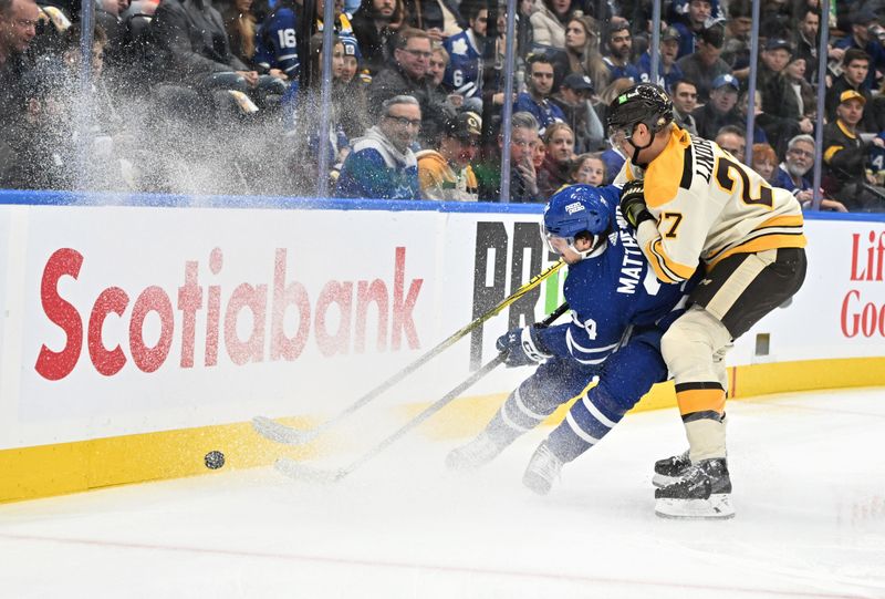 Dec 2, 2023; Toronto, Ontario, CAN; Toronto Maple Leafs forward Auston Matthews (34) and Boston Bruins defenseman Hampus Lindholm (27) battle for the puck in the first period at Scotiabank Arena. Mandatory Credit: Dan Hamilton-USA TODAY Sports