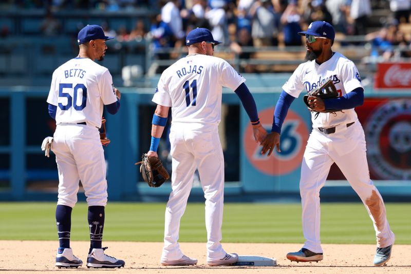 May 5, 2024; Los Angeles, California, USA;  Los Angeles Dodgers shortstop Mookie Betts (50) and second baseman Miguel Rojas (11) and outfielder Teoscar Hernandez (37) celebrate a victory after defeating the Atlanta Braves 5-1 at Dodger Stadium. Mandatory Credit: Kiyoshi Mio-USA TODAY Sports