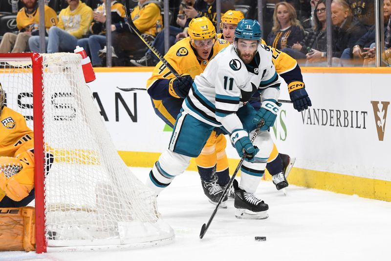 Mar 19, 2024; Nashville, Tennessee, USA; San Jose Sharks center Luke Kunin (11) handles the puck behind the net during the second period against the Nashville Predators at Bridgestone Arena. Mandatory Credit: Christopher Hanewinckel-USA TODAY Sports