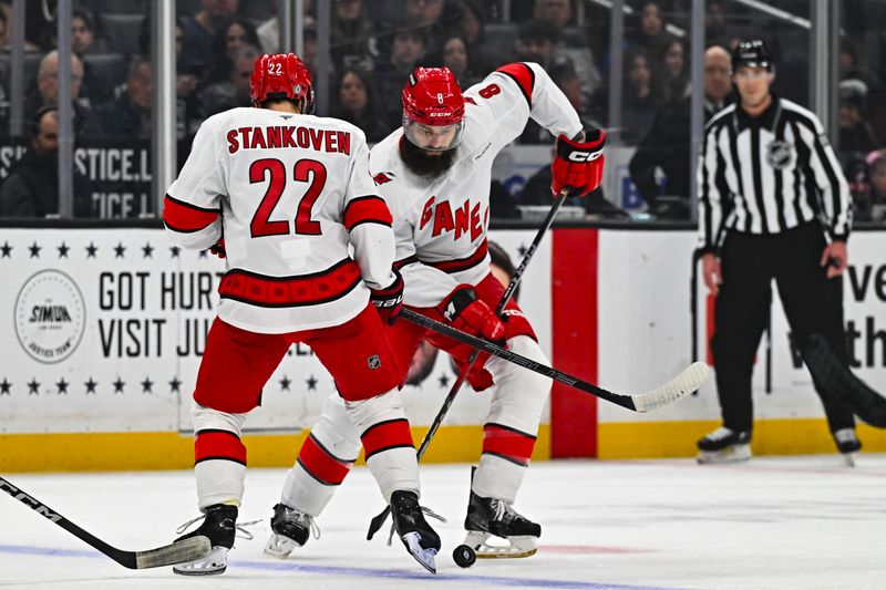 Mar 22, 2025; Los Angeles, California, USA; Carolina Hurricanes defenseman Brent Burns (8) moves the puck with center Logan Stankoven (22) against the Los Angeles Kings during the first period at Crypto.com Arena. Mandatory Credit: Jonathan Hui-Imagn Images