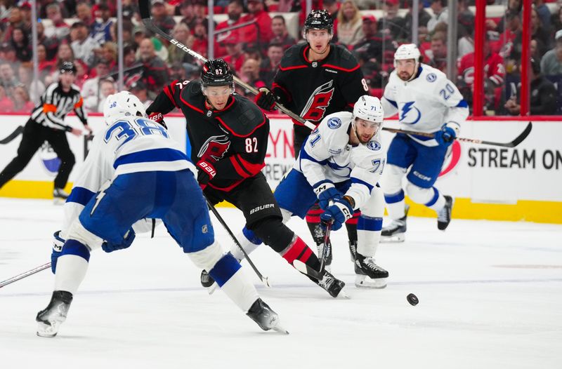 Oct 11, 2024; Raleigh, North Carolina, USA;  Carolina Hurricanes center Jesperi Kotkaniemi (82) is back checked by Tampa Bay Lightning center Anthony Cirelli (71) during the third period at PNC Arena. Mandatory Credit: James Guillory-Imagn Images