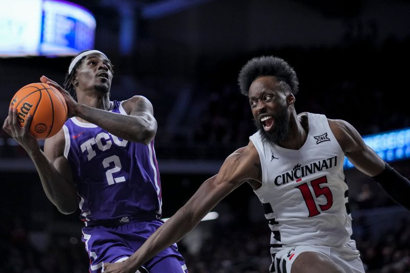 Jan 16, 2024; Cincinnati, Ohio, USA;  TCU Horned Frogs forward Emanuel Miller (2) drives to the basket against Cincinnati Bearcats forward John Newman III (15) in the second half at Fifth Third Arena. Mandatory Credit: Aaron Doster-USA TODAY Sports