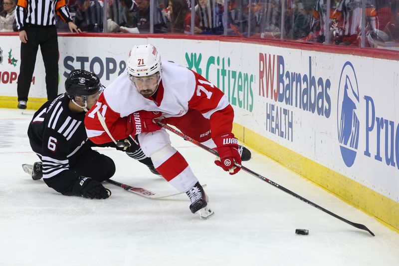 Dec 23, 2023; Newark, New Jersey, USA; Detroit Red Wings center Dylan Larkin (71) plays the puck past New Jersey Devils defenseman John Marino (6) during the third period at Prudential Center. Mandatory Credit: Ed Mulholland-USA TODAY Sports