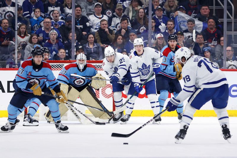 Jan 27, 2024; Winnipeg, Manitoba, CAN; Toronto Maple Leafs defenseman TJ Brodie (78) gets set to shoot on Winnipeg Jets goaltender Connor Hellebuyck (37) in the second period at Canada Life Centre. Mandatory Credit: James Carey Lauder-USA TODAY Sports