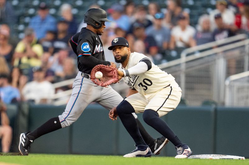 Sep 26, 2024; Minneapolis, Minnesota, USA; Minnesota Twins first base Carlos Santana (30) catches the ball from pitcher David Festa (58) as Miami Marlins shortstop Xavier Edwards (63) is checked in the first inning at Target Field. Mandatory Credit: Matt Blewett-Imagn Images