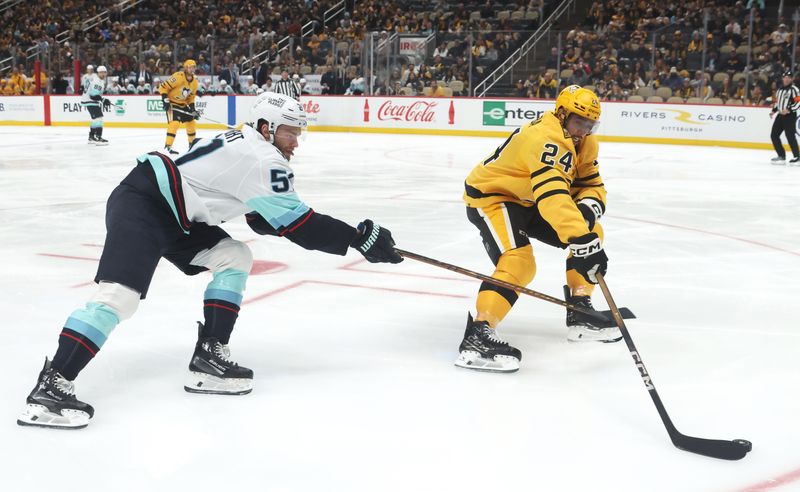 Nov 22, 2025; Pittsburgh, Pennsylvania, USA;  Pittsburgh Penguins defenseman Mathew Dumba (24) handles the puck against pressure from Seattle Kraken center Shane Wright (51) during the second period at PPG Paints Arena. Mandatory Credit: Charles LeClaire-Imagn Images