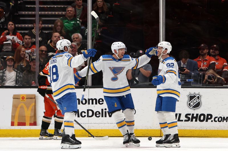Mar 8, 2026; Anaheim, California, USA;  St. Louis Blues left wing Jonathan Drouin (92) celebrates with center Robert Thomas (18) and left wing Dylan Holloway (middle) after scoring a goal during the second period against the Anaheim Ducks at Honda Center. Mandatory Credit: Kiyoshi Mio-Imagn Images