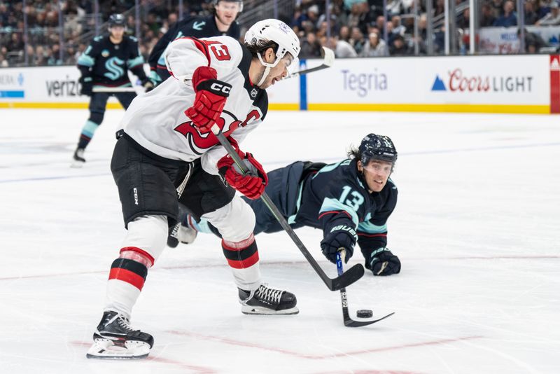 Dec 7, 2023; Seattle, Washington, USA; New Jersey Devils forward Nico Hischier (13), left, skates agianst Seattle Kraken forward Brandon Tanev (13) during the third period at Climate Pledge Arena. Mandatory Credit: Stephen Brashear-USA TODAY Sports