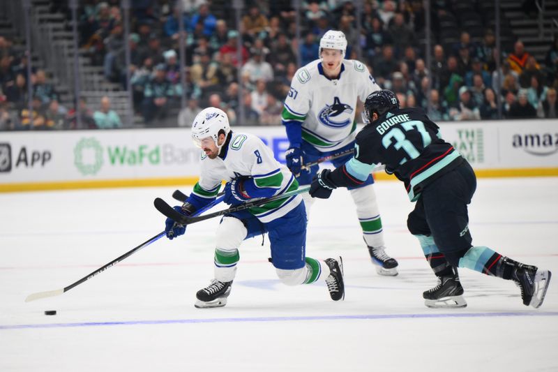 Feb 22, 2024; Seattle, Washington, USA; Vancouver Canucks right wing Conor Garland (8) advances the puck while defended by Seattle Kraken center Yanni Gourde (37) during the first period at Climate Pledge Arena. Mandatory Credit: Steven Bisig-USA TODAY Sports