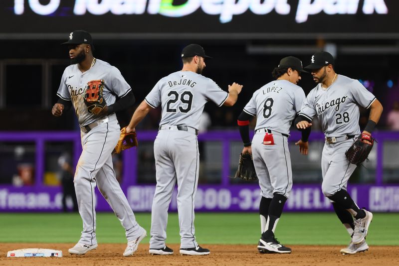 Jul 5, 2024; Miami, Florida, USA; Chicago White Sox center fielder Luis Robert Jr. (88), shortstop Paul DeJong (29), second baseman Nicky Lopez (8) and right fielder Tommy Pham (28) celebrate after the game against the Miami Marlins at loanDepot Park. Mandatory Credit: Sam Navarro-USA TODAY Sports